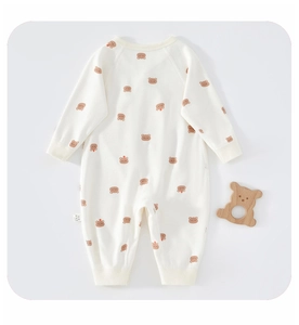 Detail of soft cotton baby romper with bear print and ribbed cuffs on grey background