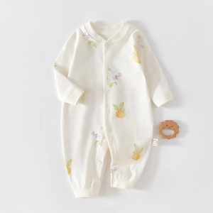 Detailed view of baby romper featuring hand-drawn lemon patterns and organic cotton texture