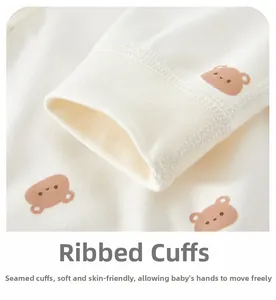 Close-up of ribbed cuffs on soft cotton baby romper with cute brown bear patterns