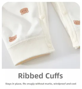 Detail of ribbed cuffs on baby cotton romper with bear print and resin snap buttons