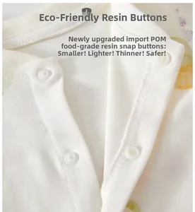 Macro detail of safe POM resin snap buttons on organic floral cotton baby romper