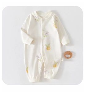Detailed flat lay of newborn cotton romper featuring delicate lemon and floral print