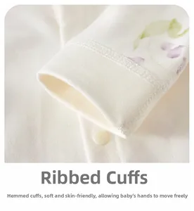 Detailed macro view of the soft ribbed cuff and cotton floral fabric on baby romper