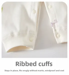 Detail of ribbed cuffs on newborn cotton romper with snap buttons and floral print