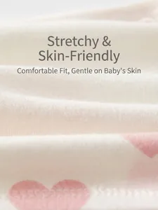 Close-up of soft ribbed cotton baby wrap top with pink polka dots and elastic fabric