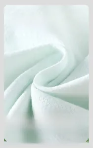 Gros plan sur le tricot de coton vert menthe montrant la texture respirante et douce