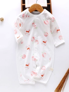 Infant summer cotton romper with pink peach and rabbit print on a wooden hanger