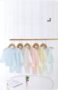 Detail of baby summer thin cotton pajama sets in multiple pastel colors hanging on wood racks