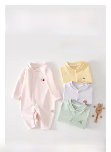Detailed macro view of pure cotton baby bodysuits with soft embroidery and snap buttons