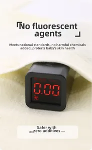 Close-up of baby clothing with a digital detector showing zero fluorescent agent content