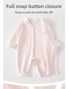 Macro shot of pink cotton baby romper showing full snap closure for easy diaper changes