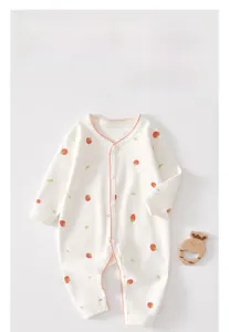 Detail of infant cotton romper featuring strawberry print and soft wavy red stitching