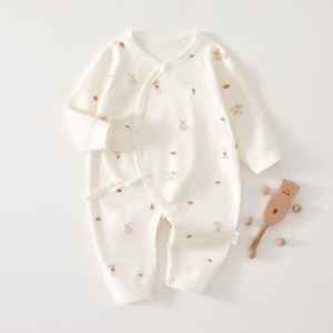 Detail of soft cotton baby romper with cute bear and rabbit patterns and side ties