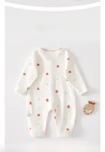 Detail of soft cotton baby romper featuring cute strawberry and green bow prints