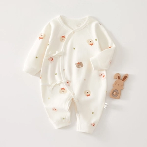 Detail of baby cotton romper with cartoon bear prints and ribbon tie closure