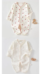 Close-up of baby long-sleeve rompers with heart prints and colorful wavy stitched edges