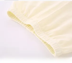 Detail of baby pants wide elastic waistband in soft light yellow cotton knit fabric