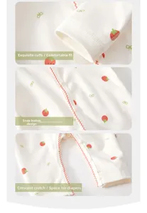 Close-up of strawberry print baby romper with ribbed cuffs, metal snaps and crescent crotch