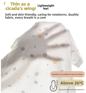 Détail d'un body bébé en coton ultra-fin et respirant avec des motifs à pois discrets