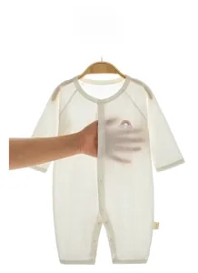 Close-up of lightweight breathable white baby romper with rainbow embroidery detail
