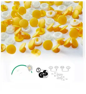 Detail of high-quality yellow and white POM plastic snap buttons for baby rompers