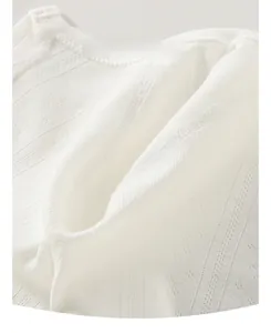 Detail of soft breathable cotton baby romper with vertical texture and snap button