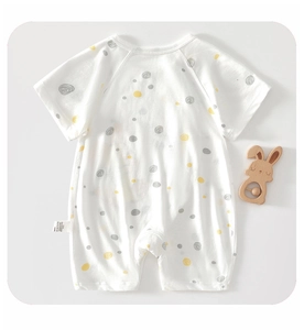Détail d'un barboteuse pour bébé en coton à manches courtes avec motif à pois colorés