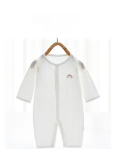 Detailed macro view of white baby romper featuring vertical jacquard texture and rainbow embroidery