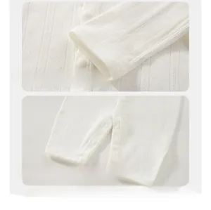 Detail of pointelle knit fabric, cuffs and moon-shaped crotch on infant long sleeve bodysuit