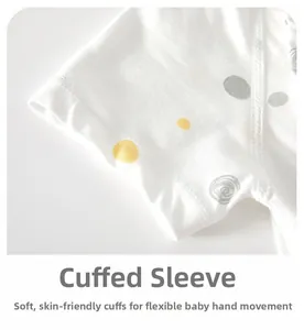 Gros plan d'une manche de barboteuse en coton pour bébé avec bord ourlé et pois colorés