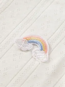 White knit baby bodysuit with hollow-out pattern and rainbow embroidery detail