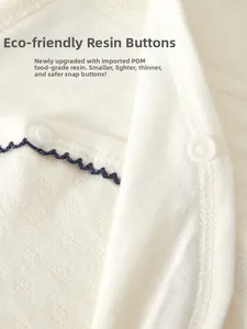 Detailed close-up of eco-friendly resin snap buttons on soft cotton newborn bodysuit