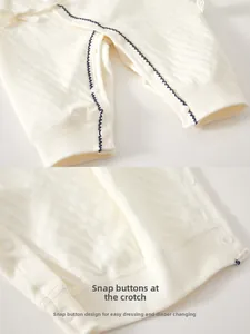 Detail of baby romper with blue wave trim and white resin snap buttons for easy diapering