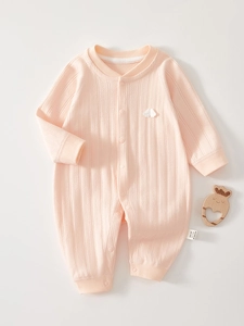 Detail eines Baby-Stramplers aus hellrosa Rippstrick-Stoff mit Druckknopfverschluss