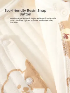 Macro detail of eco-friendly resin snap button on baby cotton bodysuit fabric