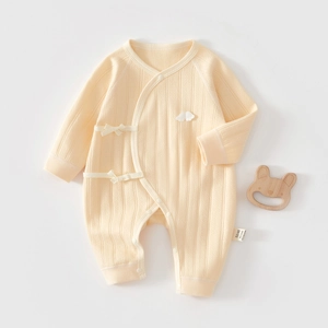 Detail showing soft cotton texture and knot closure of a yellow newborn jumpsuit