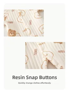 Close-up of resin snap buttons on a quilted baby romper with cartoon bear prints