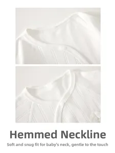 Detail of soft ribbed cotton baby bodysuit featuring bound neckline and wing embroidery