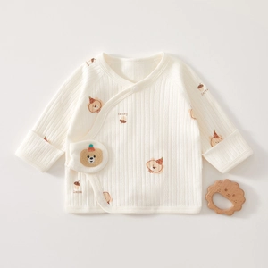 Détail d'un haut cache-cœur en coton côtelé pour bébé avec broderie d'ourson