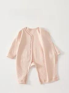 Close-up of pink cotton infant romper with waffle texture and convenient snap buttons