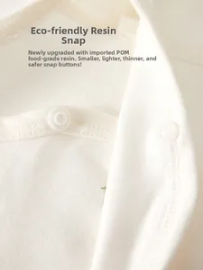 Close-up of eco-friendly food-grade POM resin snaps on cotton newborn baby clothes