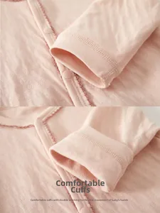 Detail of pink heart pointelle cotton baby bodysuit showing double-stitched sleeve cuffs