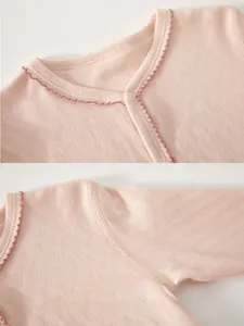 Close-up of pink cotton baby romper featuring breathable mesh fabric and delicate lace trim