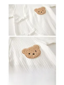 Detail of baby romper featuring ribbed cotton fabric and cute plush bear embroidery