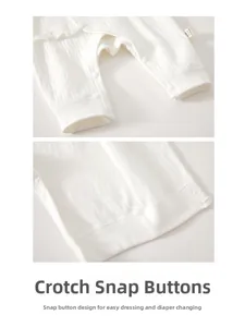 Detail of baby cotton romper showing quilted fabric texture and snap buttons for diapering