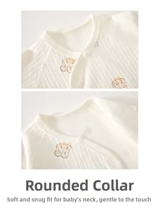 Close-up of baby romper collar with white snap buttons and cute bear pattern on soft cotton