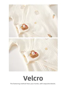Detail view of cotton baby bodysuit featuring adjustable velcro closure and cute patches