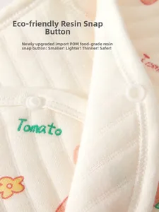 Detailed macro view of infant cotton suit featuring POM food-grade snaps and tomato prints