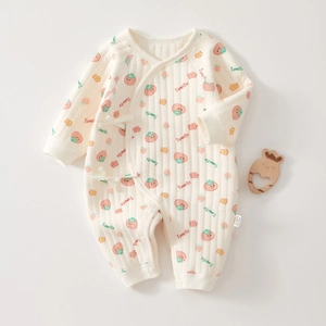 Detail of baby quilted cotton romper with tomato print and side bow tie fastening