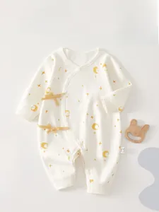 Detail of newborn cotton bodysuit featuring yellow moon stars print and side-tie closure